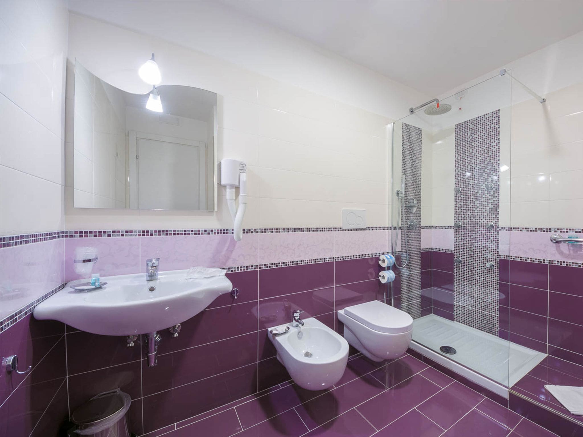 A modern bathroom with a sink, bidet, and shower.