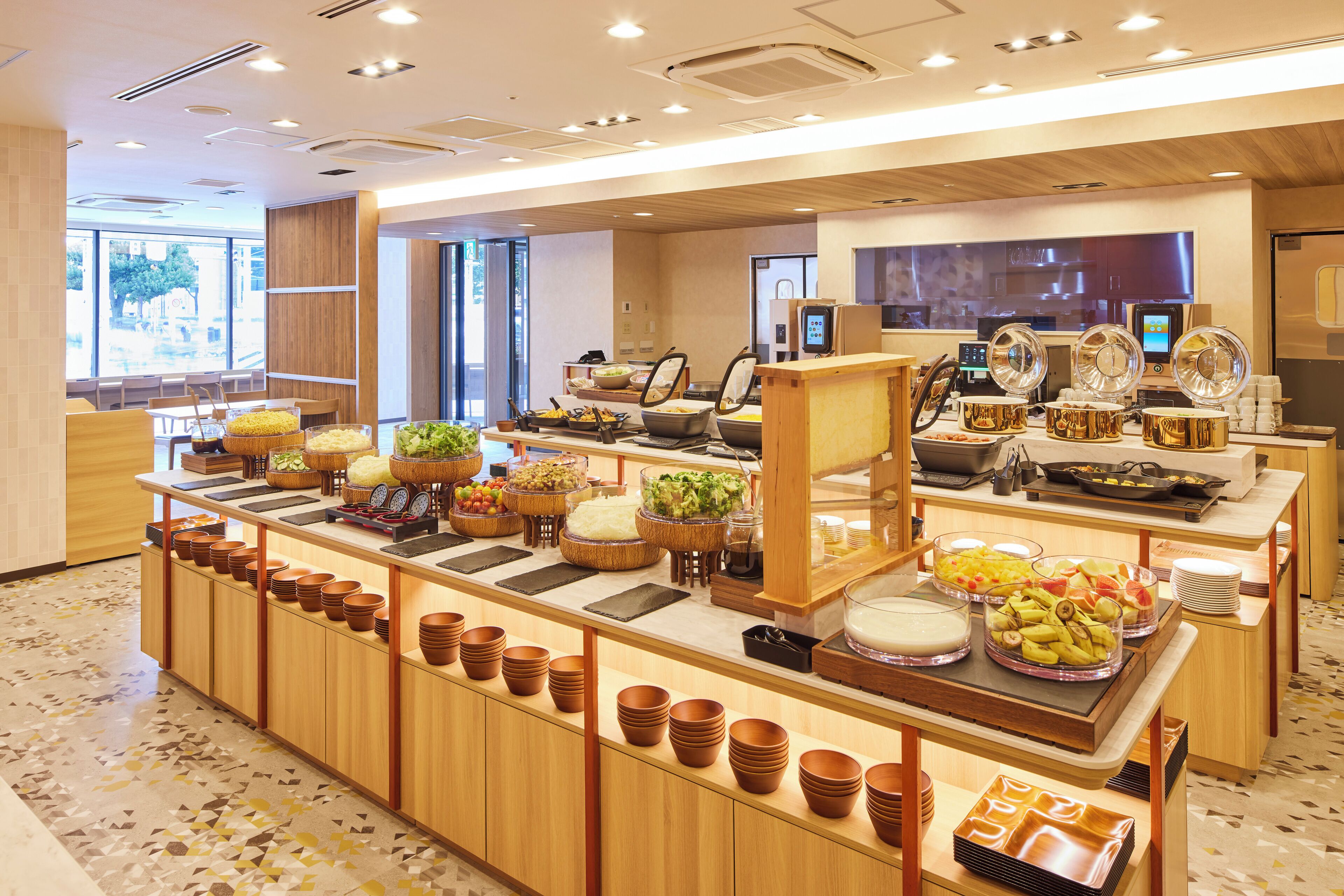 Disposição de buffet com diversos alimentos e utensílios de servir.