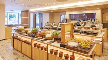 Disposição de buffet com diversos alimentos e utensílios de servir.