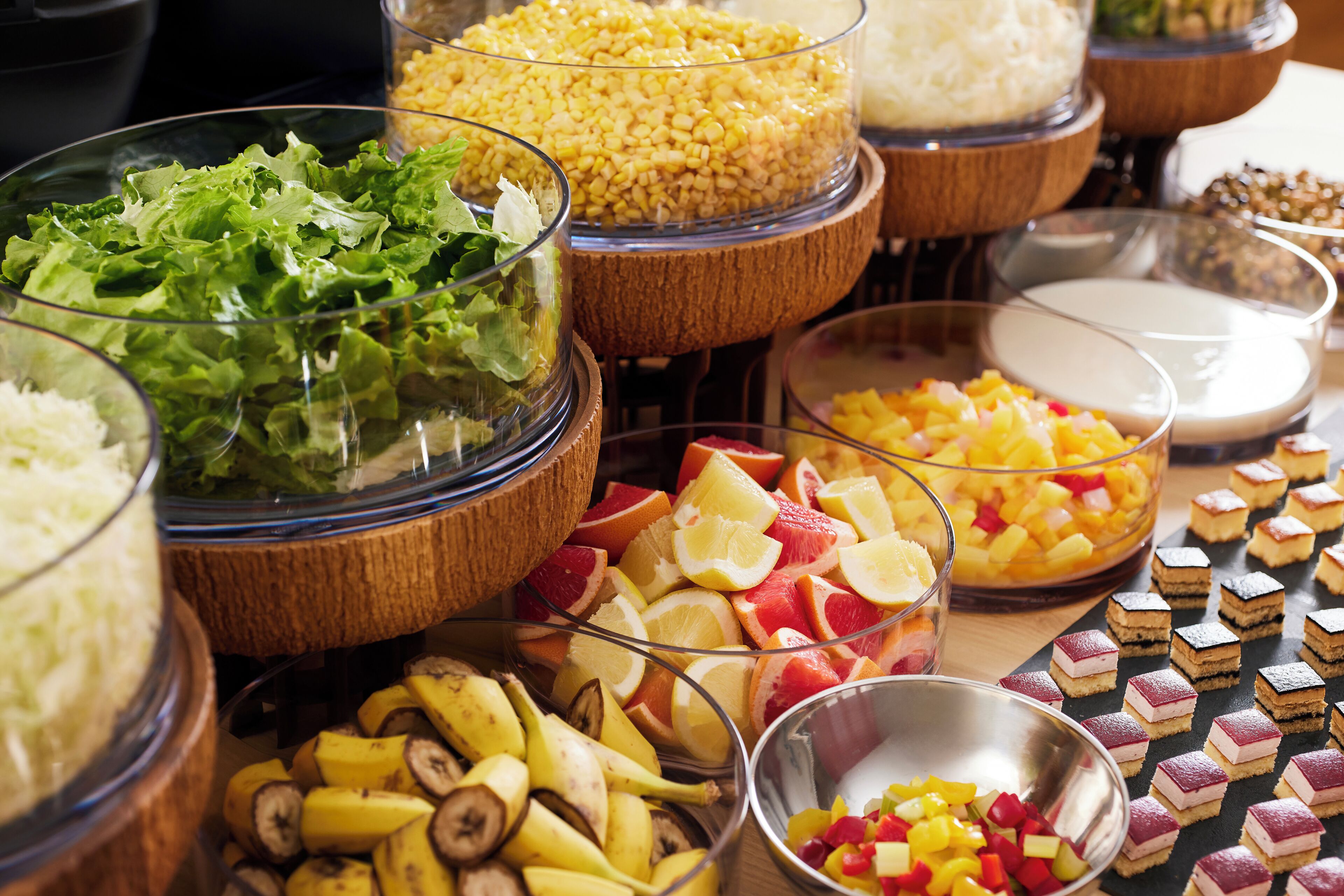 A buffet with various food items including fruits, vegetables, and desserts.