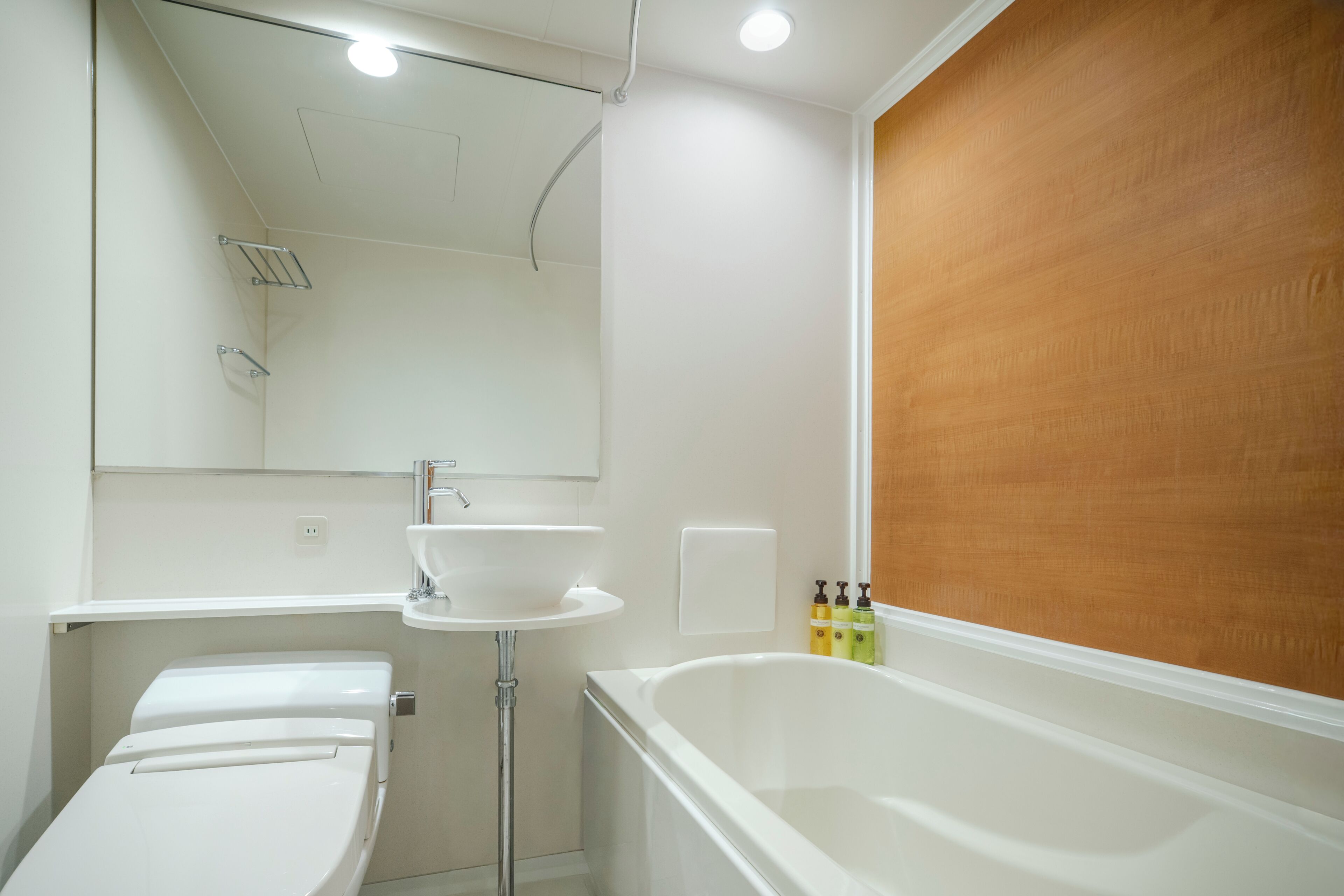 Une salle de bain avec une baignoire blanche, un lavabo et un miroir.