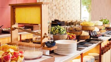 Disposição de buffet com diversos alimentos e um aplicador de mel.