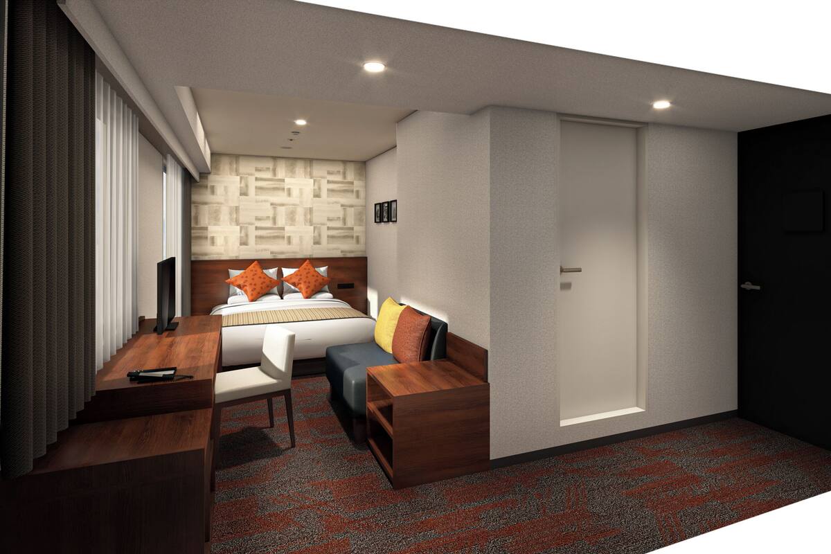 Una habitación de hotel moderna con una cama, un escritorio, una silla y un televisor.