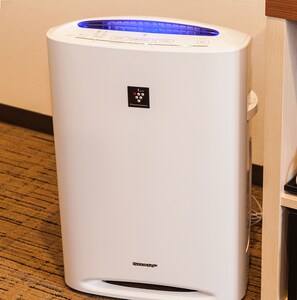 A white portable heater with a blue light on top, a control panel, and a logo on the front. - Hotel MyStays Nagoya - Sakae (Nagoya)