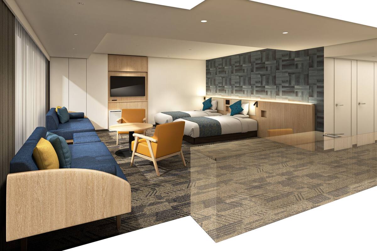Una habitación de hotel moderna con sofá, dos camas individuales, un escritorio y televisión.