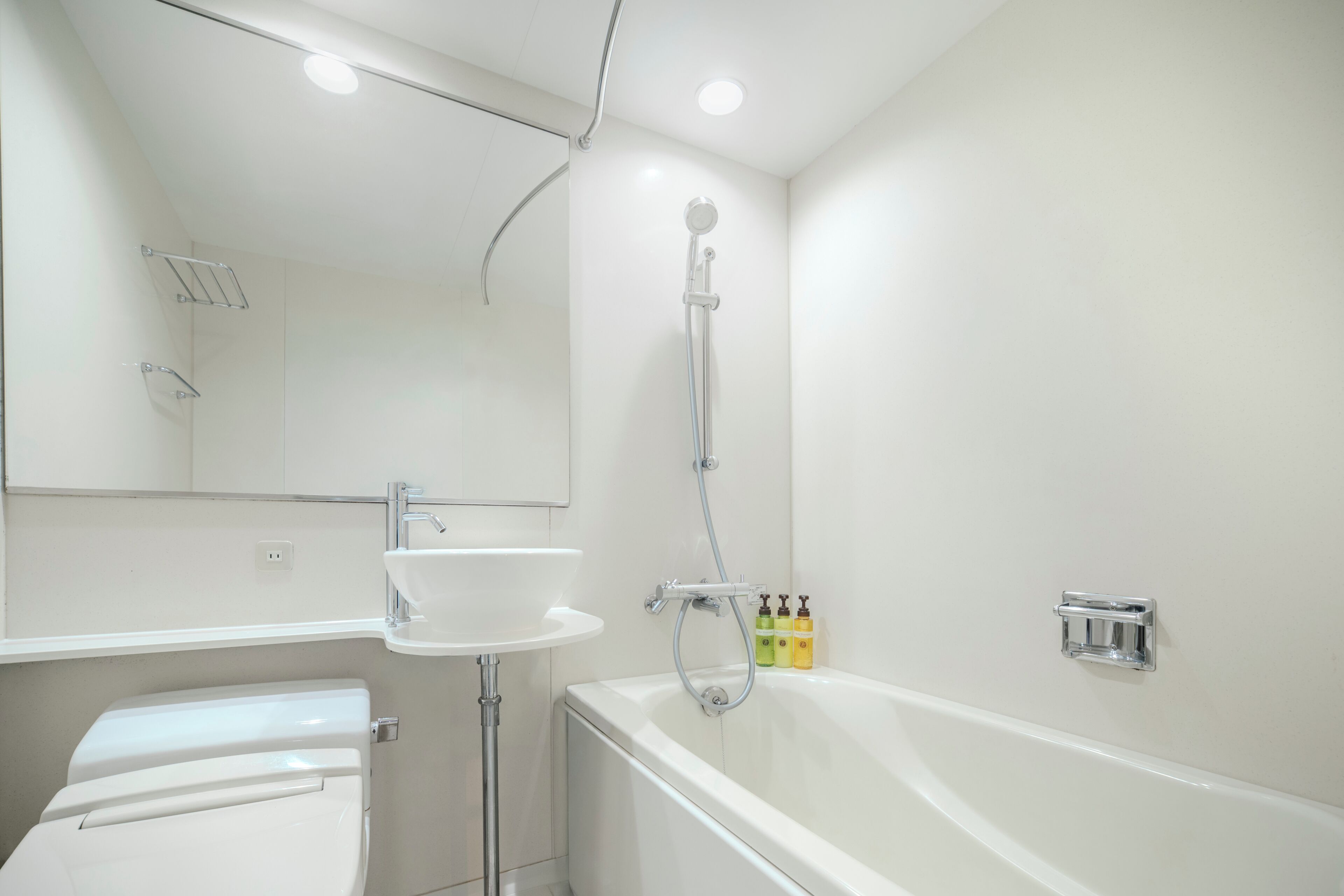 A modern bathroom with a white sink, a bathtub, and a shower.