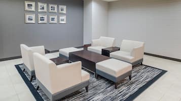 A modern lounge area with a sofa set, a coffee table, and a rug.