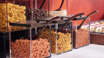 Verschiedene Snacks in unterschiedlichen Farben und Texturen, ordentlich in Behältern mit Holzgriffen angeordnet.