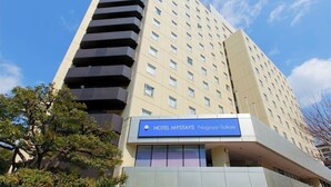 Un hôtel à plusieurs étages, reconnaissable à son grand panneau bleu sur lequel on peut lire « HÔTEL MYSTAYS Nagoya-Sakai ».