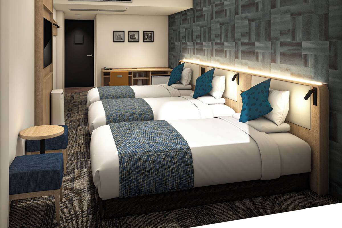 Una habitación de hotel moderna con una cama grande, un escritorio y una zona de estar.