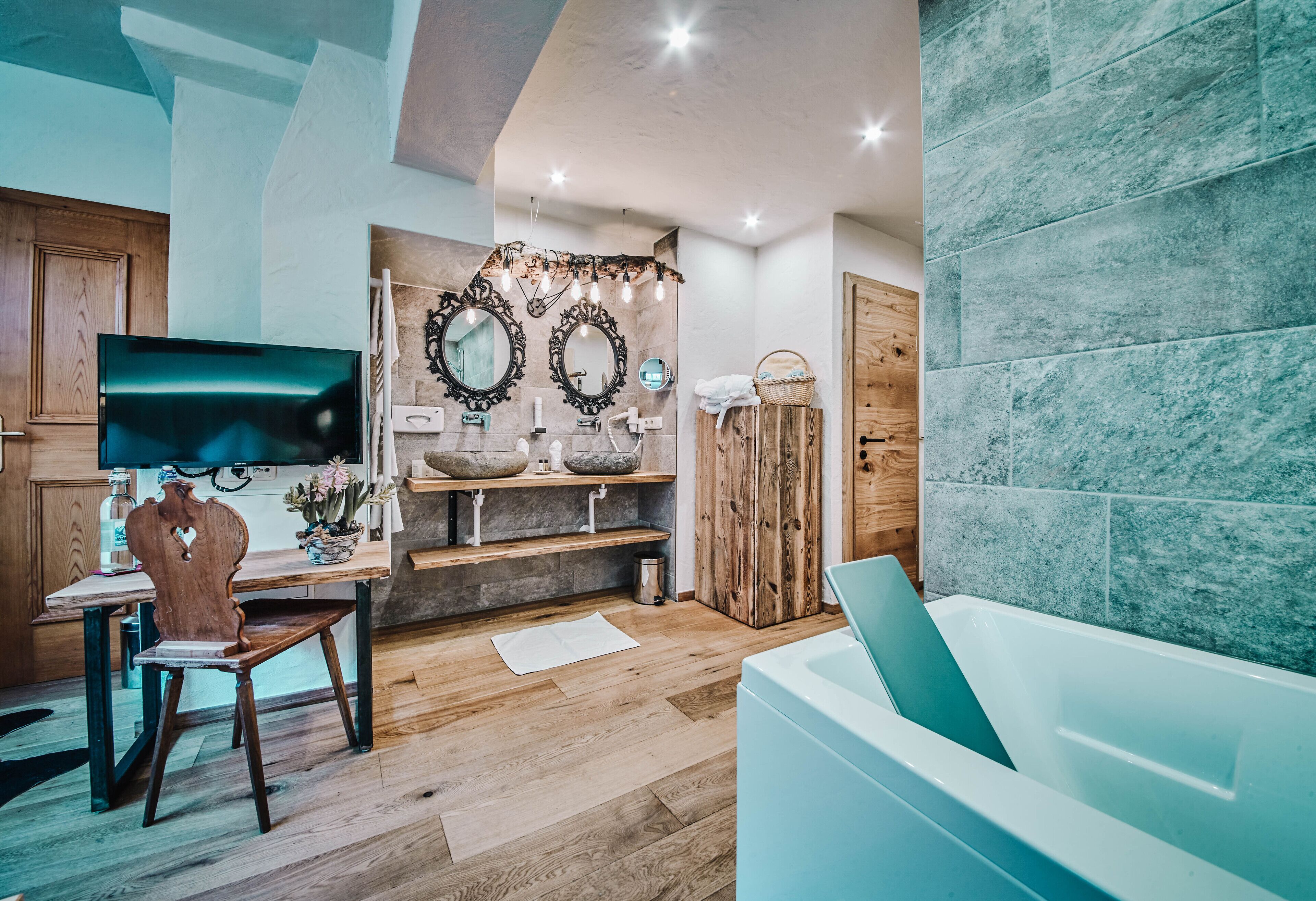A modern bathroom with a bathtub, wooden vanity, and a mirror with decorative lights.