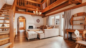 Ein geräumiger Wohnbereich mit einer Holztreppe, einem weißen Sofa und einem Holztisch.