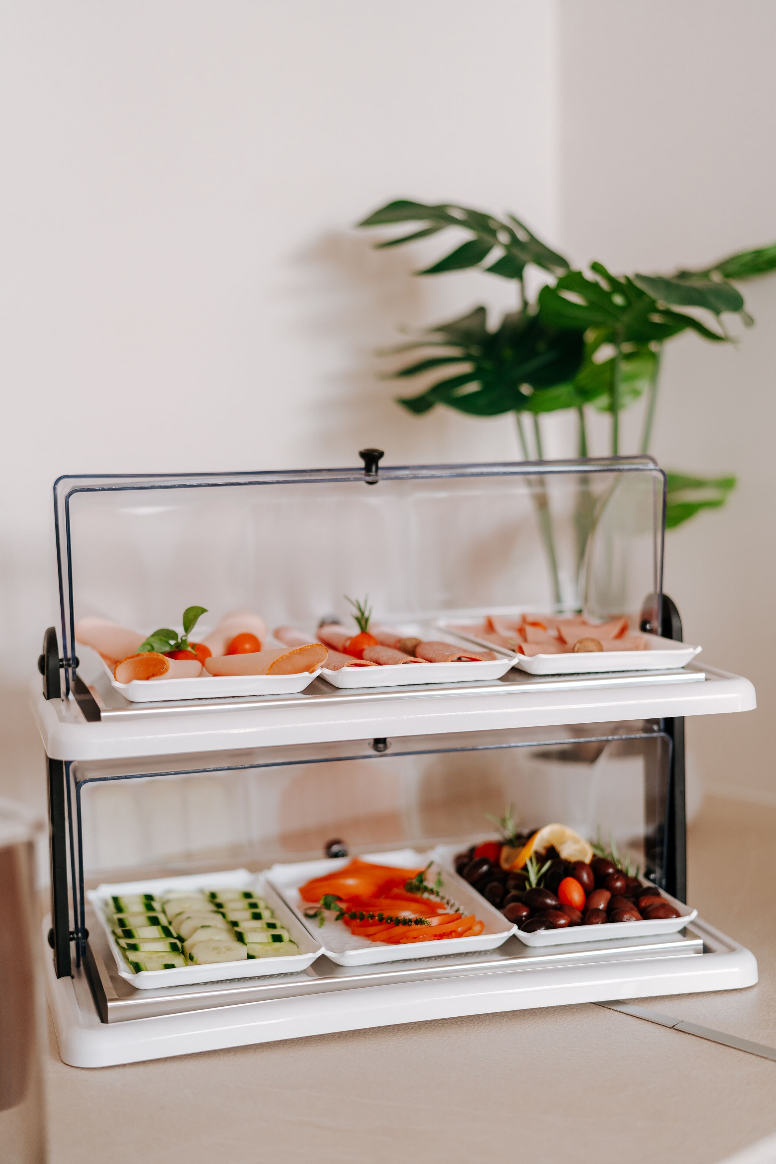 A three-tiered food display stand with various appetizers.