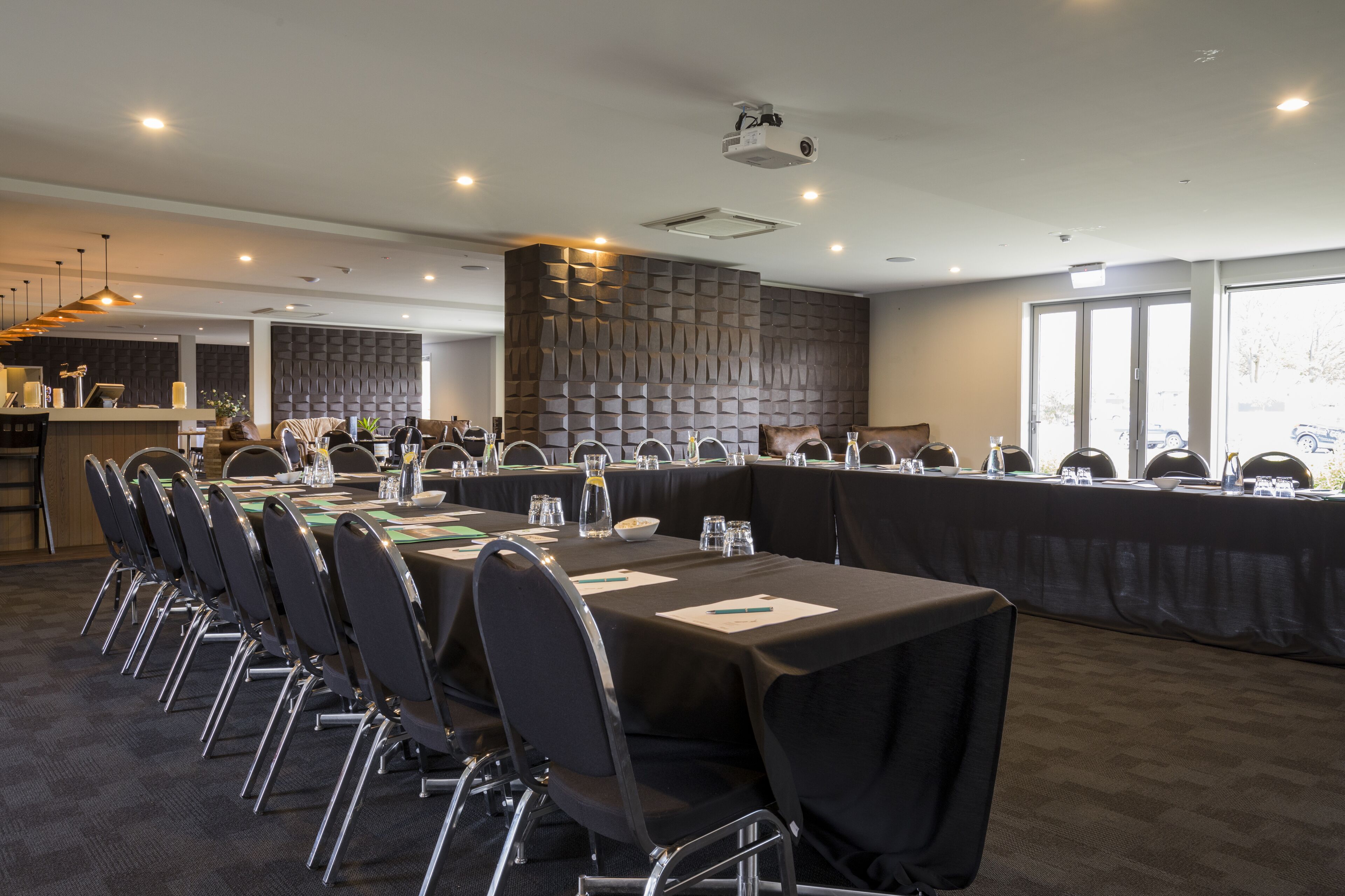 Une salle de conférence équipée d’une longue table, de chaises et d’un projecteur.