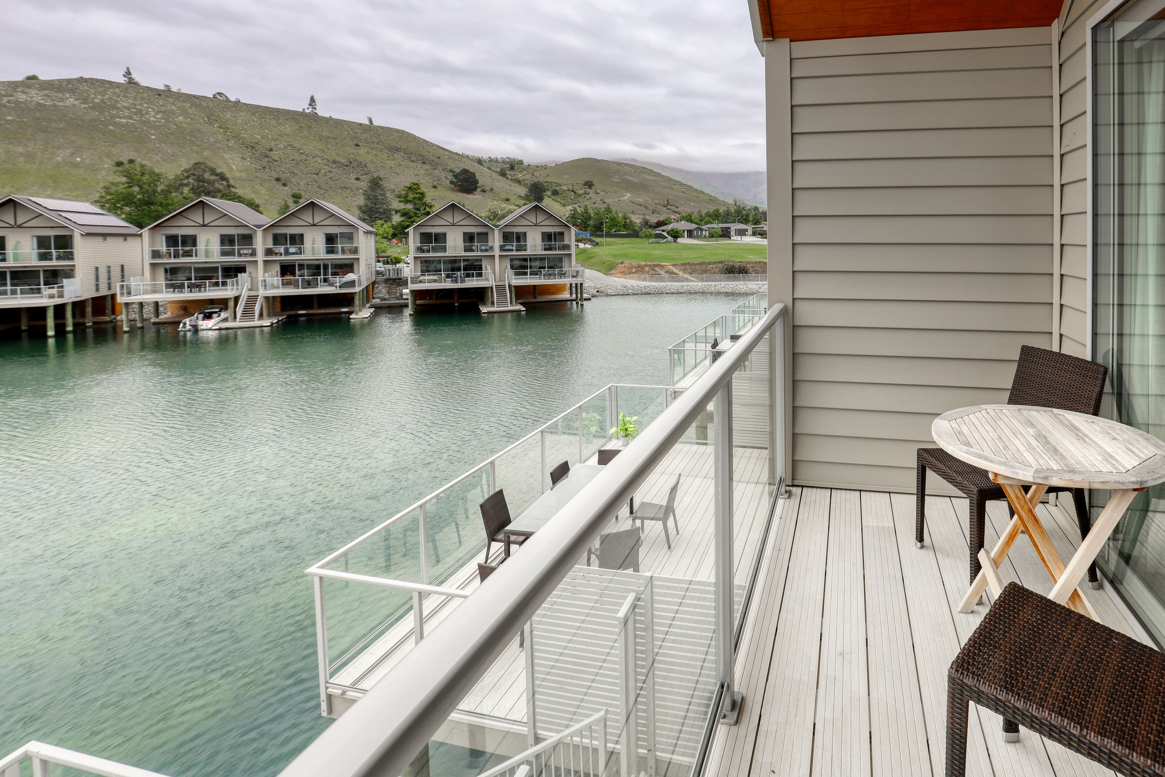 A balcony with a view of a water body and houses.