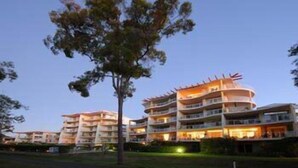 Ein mehrstöckiges Hotel mit modernem architektonischen Design, mit Balkonen und einem zentralen Innenhof.