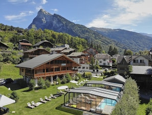 A mountain resort with chalet-style buildings, a pool area, and a mountain backdrop.