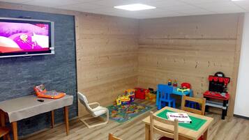 Children can play and relax in this room with a play mat, toys, and a TV.