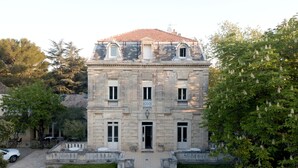 Un edificio histórico con fachada simétrica, ventanas amplias y una entrada central.