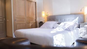 Hotellihuone, jossa on suuri sänky, yöpöytä, lamppu ja vaatekaappi.