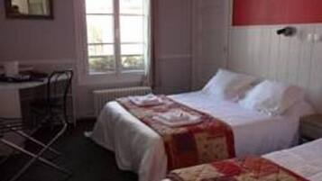 A room with two beds, a desk, and a chair.