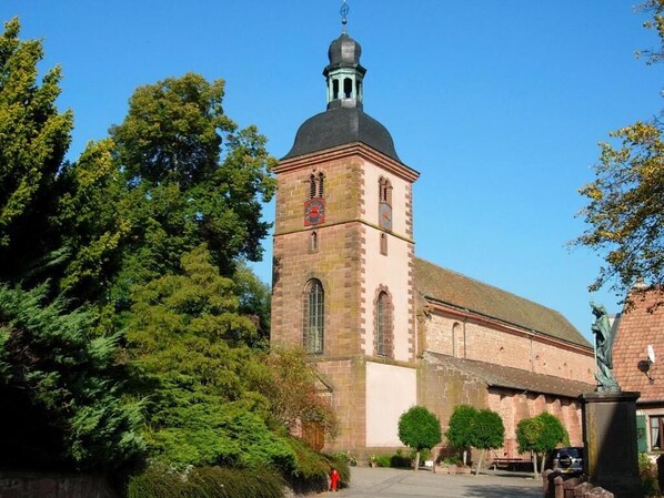 A historic church with a prominent tower and a dome, surrounded by lush greenery. - Kleiber (Saint-Jean-Saverne)