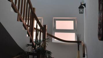A staircase with wooden railings leading to a loft area with skylights and a circular skylight.