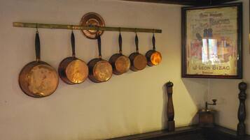 A wall-mounted rack with several copper pots and pans.