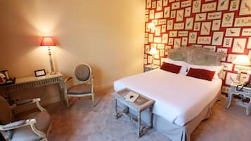 A neatly arranged bedroom with a large bed, two bedside tables with lamps, a chair, and a desk.