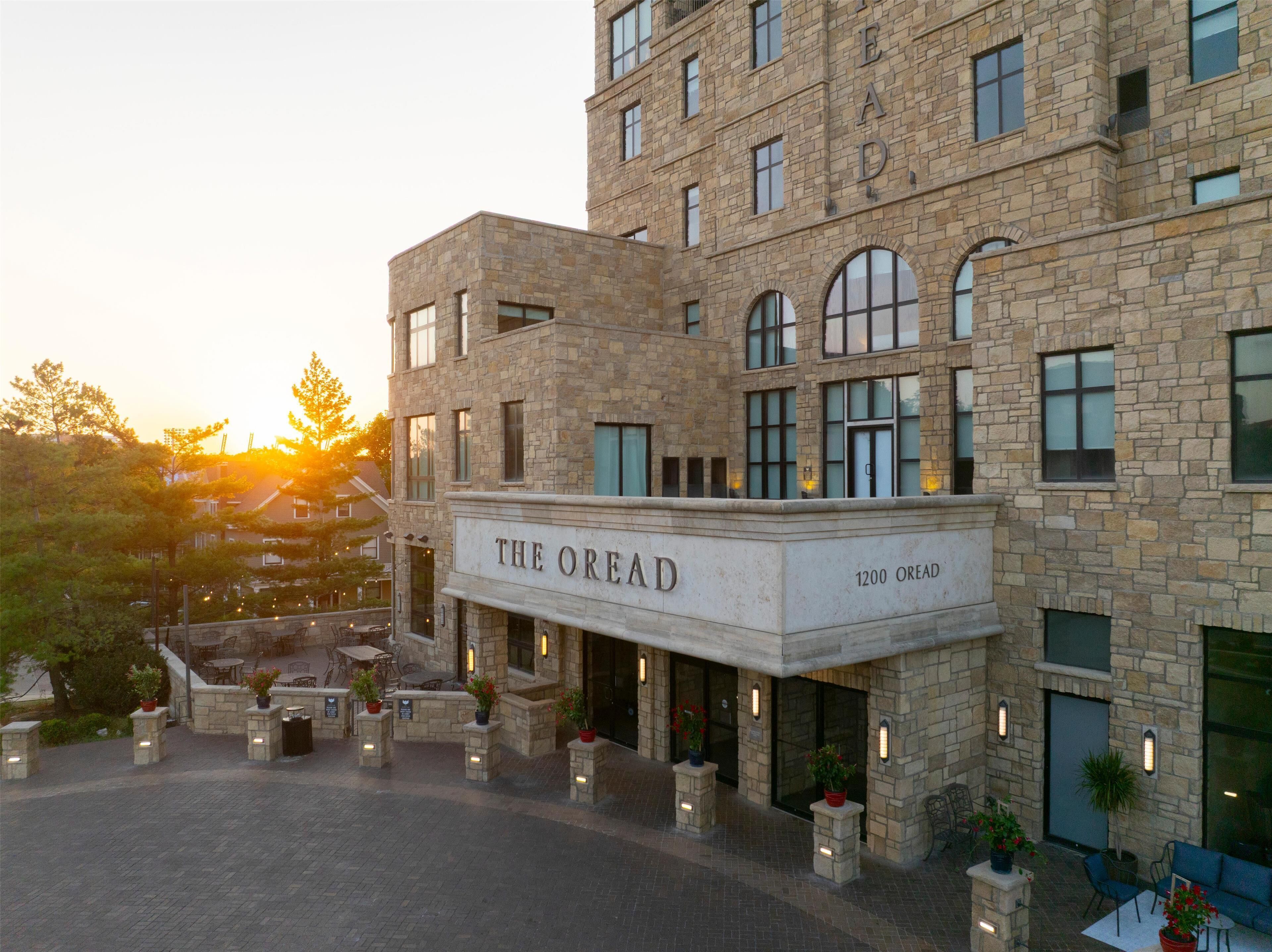 Ein Steingebäude mit der Beschriftung "THE OREAD", das einen Innenhof mit Außenbestuhlung und Blumentöpfen zeigt.