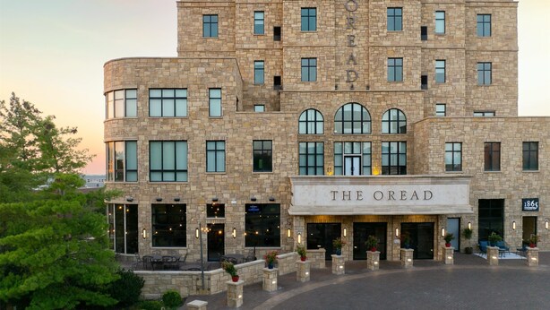 Un edificio de varios pisos con fachada de piedra, múltiples ventanas y un letrero que dice "THE OREAD".