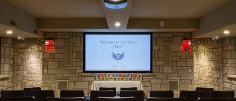 A conference room with a screen displaying a welcome message and a birthday banner.