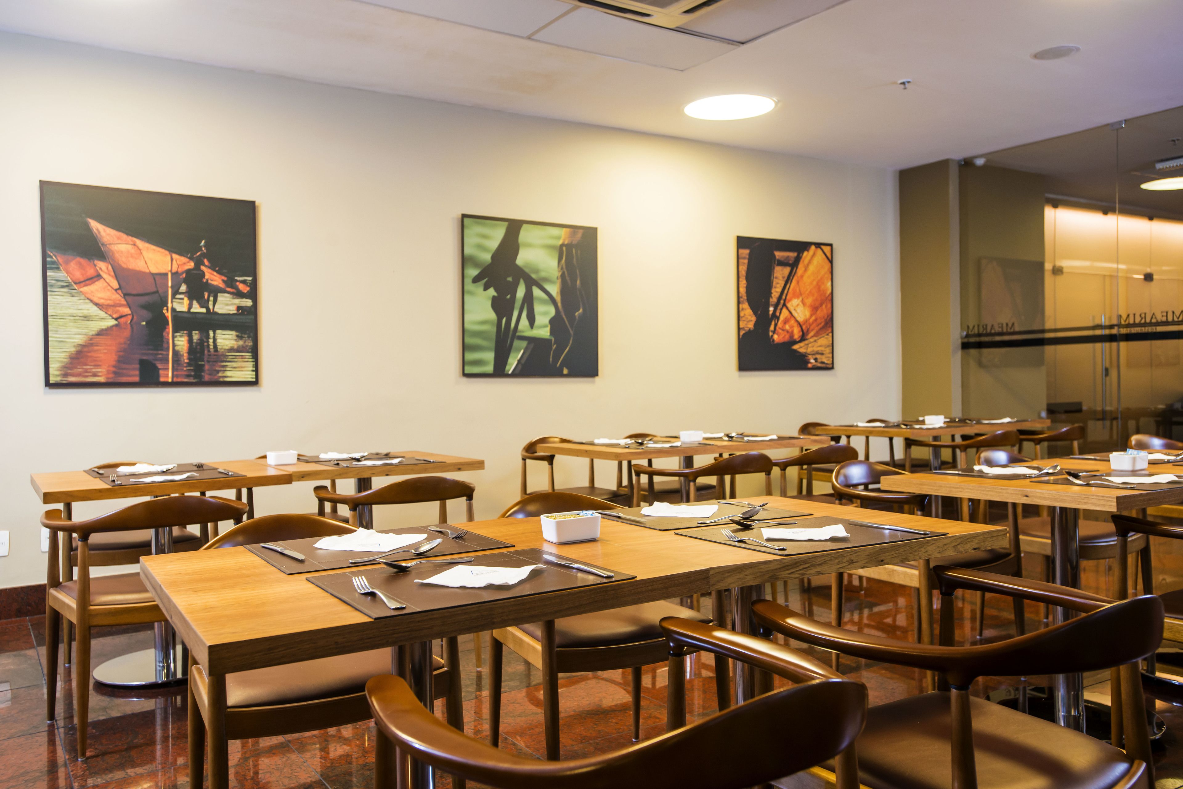 A conference room with multiple tables and chairs, equipped with nameplates, notepads, and pens.