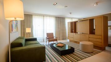 Uma sala de estar moderna com um sofá verde, uma mesa de centro, um abajur, uma poltrona e um armário de madeira grande.