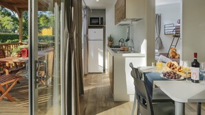 Una cocina moderna con microondas integrado, un lavamanos y una pequeña zona de comedor con una mesa dispuesta para el desayuno.