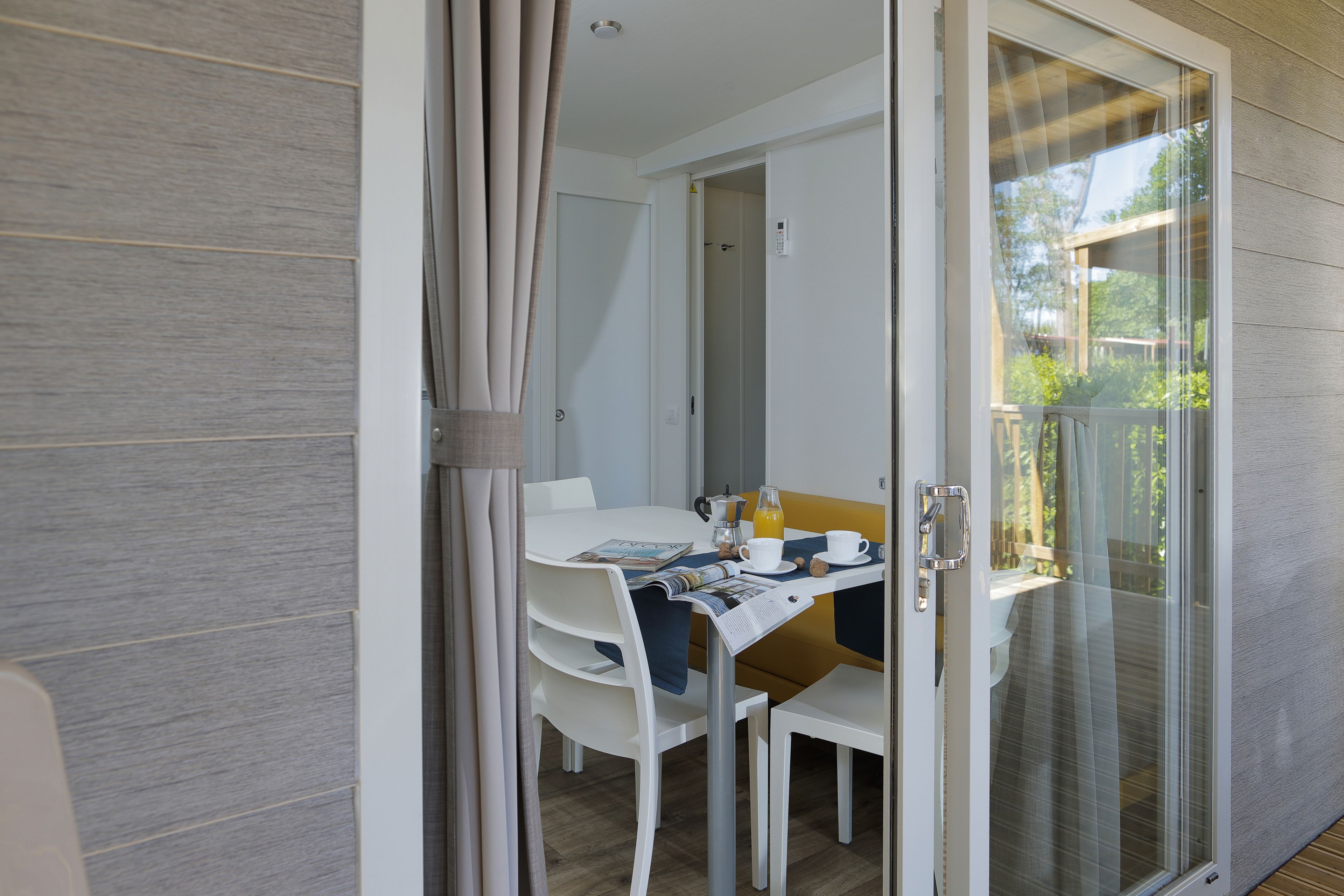 A dining area with a table, chairs, and a glass door leading to an outdoor space.