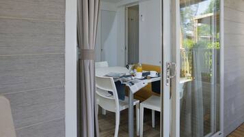 A dining area with a table, chairs, and a glass door leading to an outdoor space.