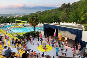 Un espace piscine doté d’un toboggan et d’une scène pour les spectacles.