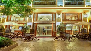 A hotel with outdoor seating, a covered area, and a multi-story building with illuminated windows. - Conifer Boutique Hotel (Hanoi)