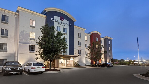 A hotel with a modern design, featuring a prominent sign for Candlewood Suites. There are multiple parking spaces visible in front of the building. - Candlewood Suites Cape Girardeau by IHG (Cape Girardeau)