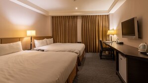 Une chambre d’hôtel avec deux lits, un bureau, une télévision et une machine à café.