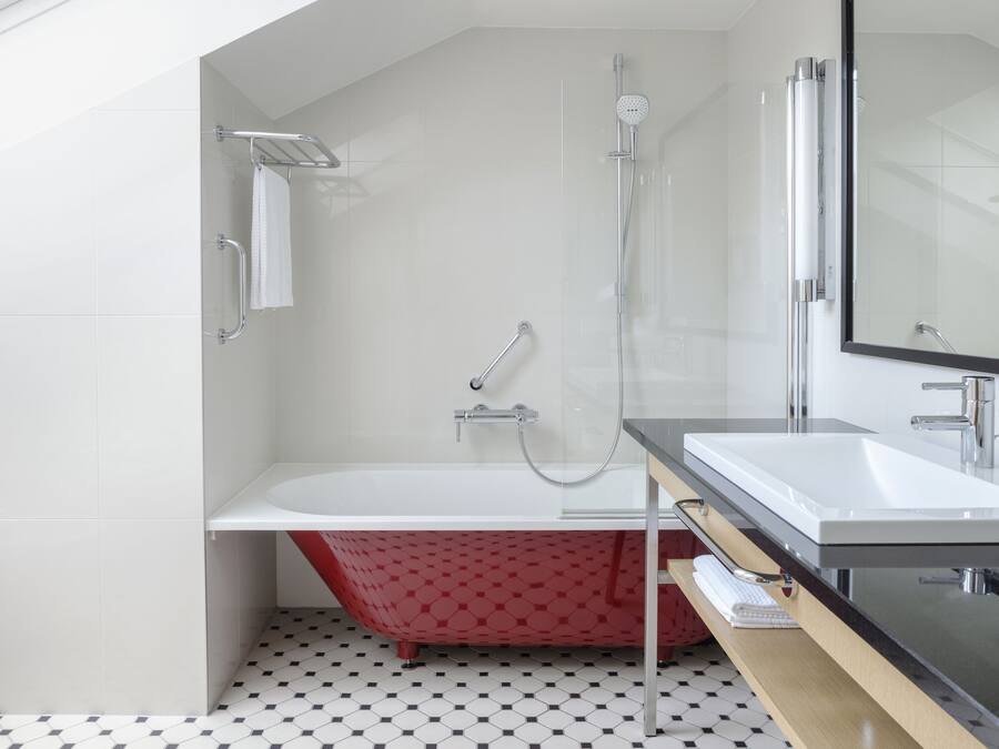Un baño moderno con una bañera independiente, una ducha con mampara de vidrio y un espejo grande sobre el lavabo.