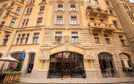 A historic building with ornate architectural details, a prominent entrance, and a bicycle parking sign.