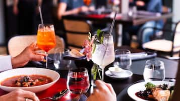 A dining table with various dishes, drinks, and utensils.