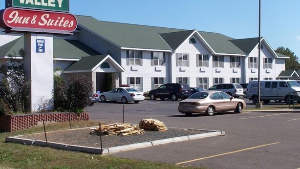 A motel named River Valley Inn & Suites with a sign indicating indoor pool and spa. - River Valley Inn & Suites (Osceola)