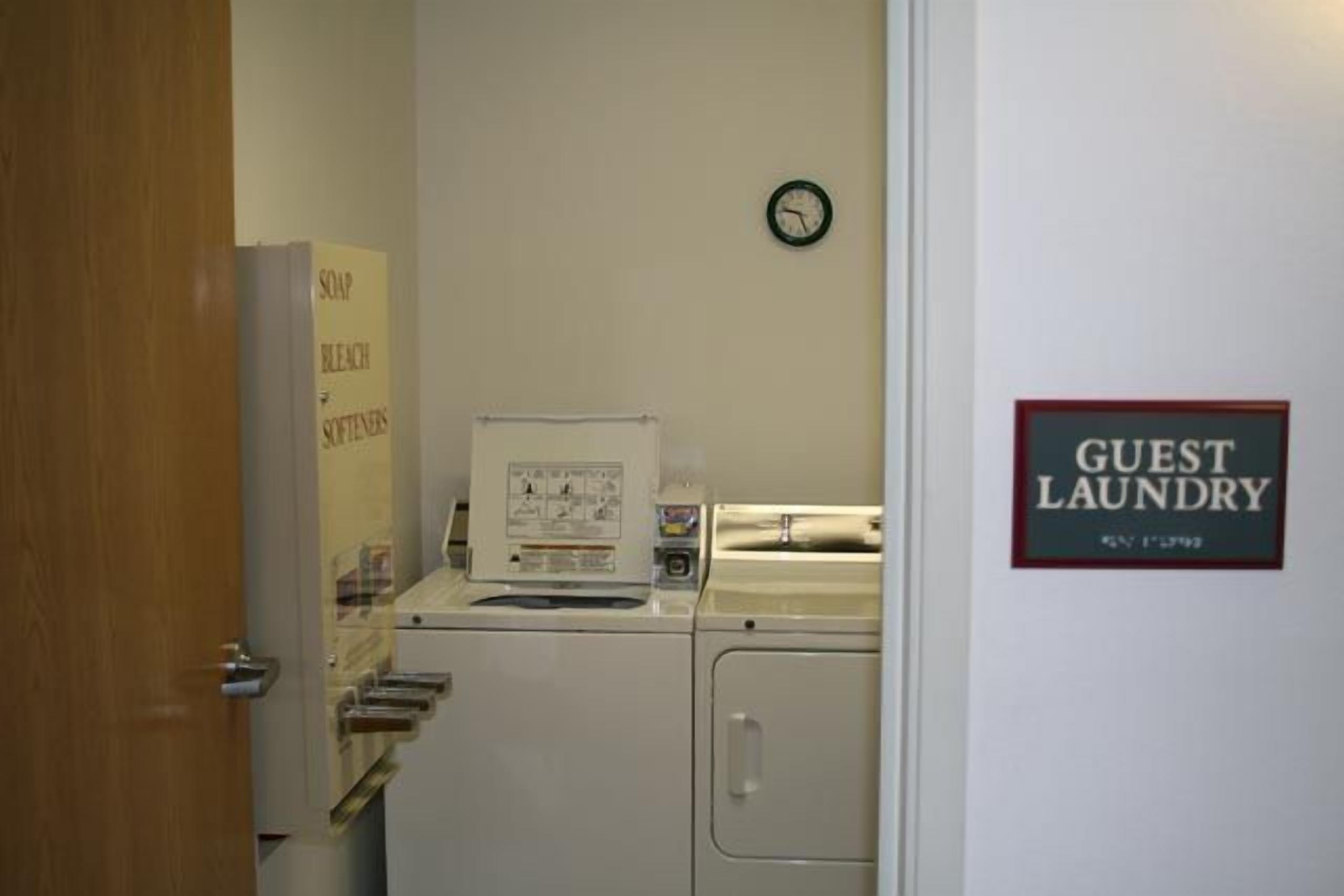A laundry area with a sign reading "GUEST LAUNDRY" and a clock on the wall.
