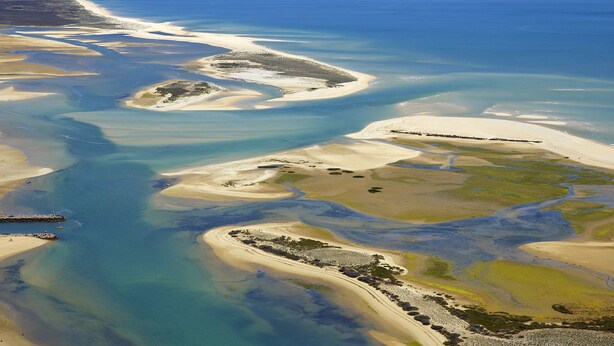 An aerial view of a coastal landscape with sandy beaches and clear blue waters. - Real Marina Residence (Olhao)