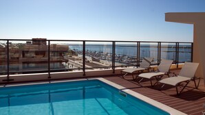 A rooftop pool with a clear view of a marina and boats. - Real Marina Residence (Olhao)