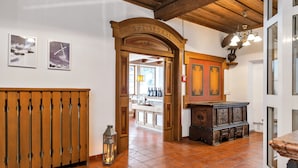 Ein Korridor mit einer Holztür mit der Aufschrift 'SPEISESAAL', einem gefliesten Boden und einem Holzschrank.
