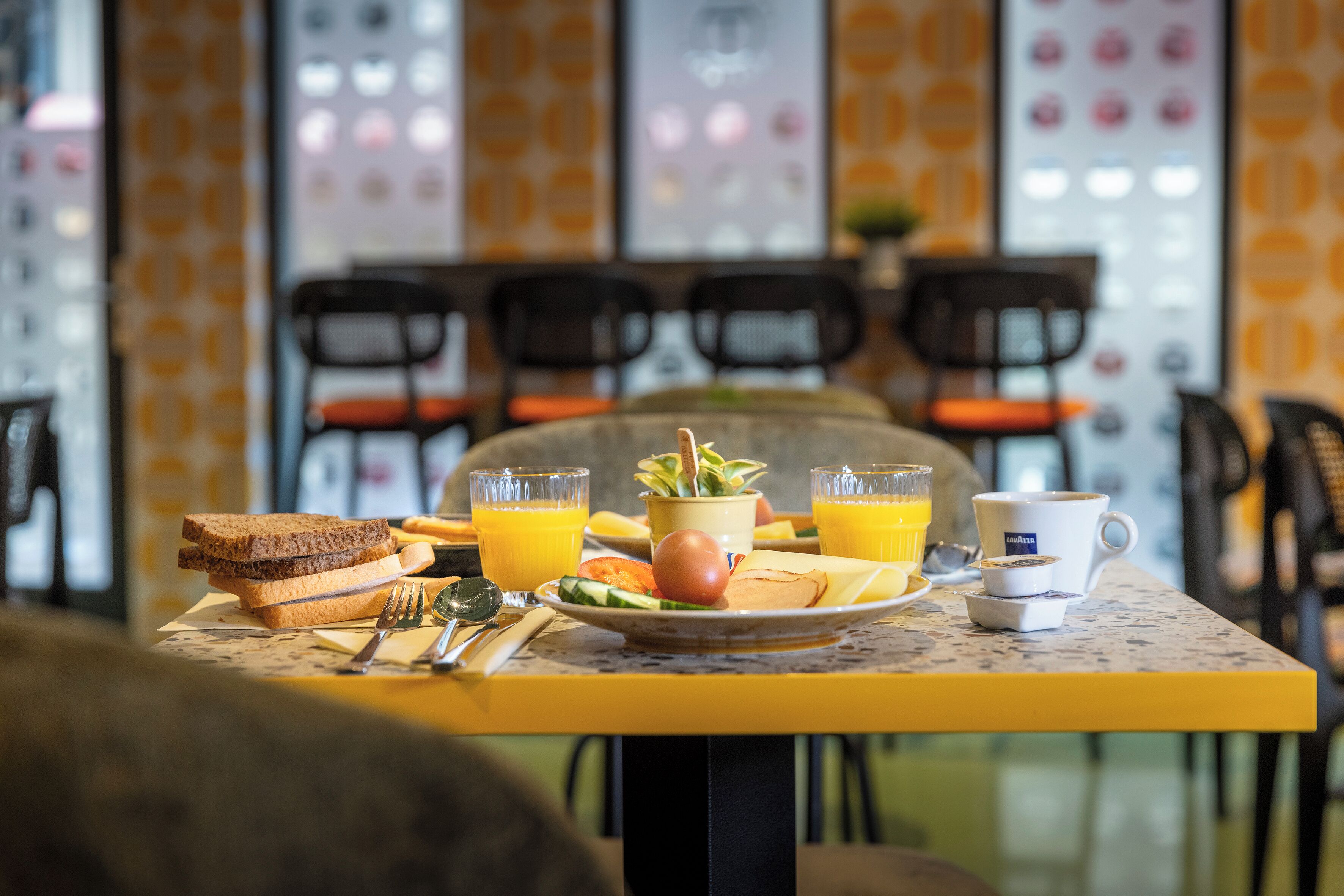 A breakfast table with toast, fruit, juice, and a coffee cup.